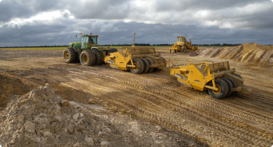 Carry graders excavating a pit for clay spreading