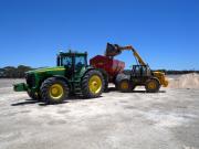 Photograph of bulk gypsum being loaded into a tractor drawn spreader for use on sodic soil