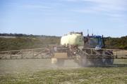 Boom spray applying chemical over pasture paddock