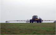 Ground rig spraying chemical onto pasture