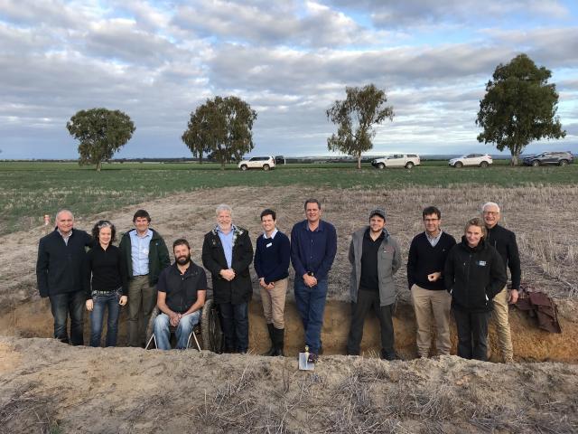 Soils tour participants stand in a soil pit that is looking at the impact of deep ripping on soil movement, at a research site on a property east of Meckering.