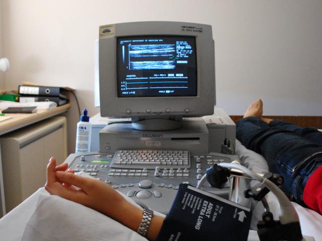 Vascular function health test being run on a volunteer. Arm with a blood pressure cuff and computer monitor showing readings from vascular flow mediated dilation test.