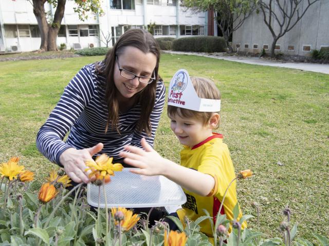 Lady and child looking for pests in garden