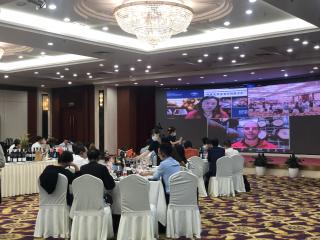 People in a function room with a big screen overhead. People in a function room with a big screen overhead.