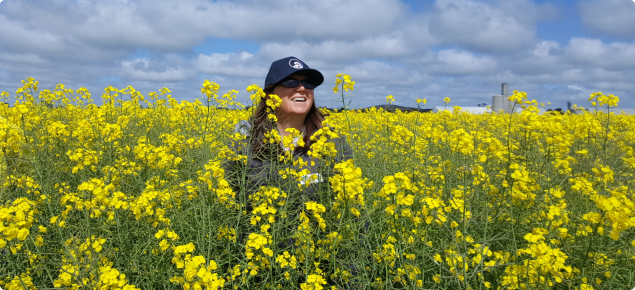 DPIRD regional agronomist standing in tall canola crop