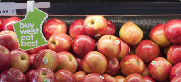 Sundowner™ apples on a supermarket shelf with a Buy West Eat Best campaign label hanging above..