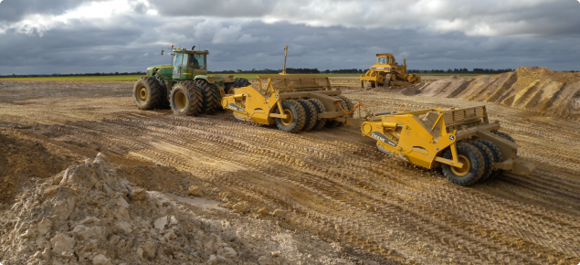 Carry graders excavating a pit for clay spreading
