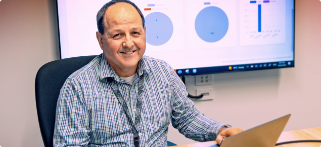 Man with laptop which shows the new Extrata Data Sharing Platform on the screen.