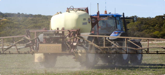 Boom spray applying chemical over pasture paddock