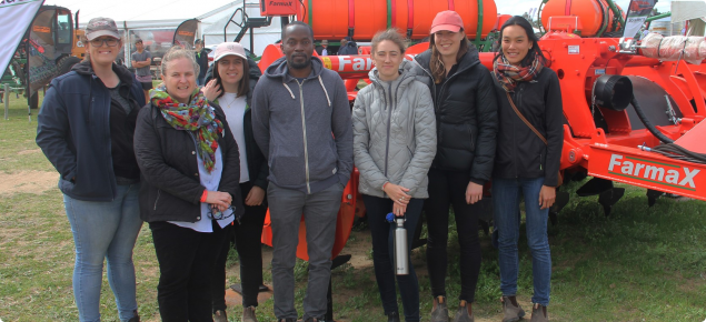 Seven people posing in front of machinery at Dowerin Field Day