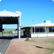 The Kununurra quarantine checkpoint, a white building alongside a large, tall, open backed shed used for inspections.