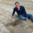DAFWA officer sitting near sandy soil that has been deep ripped